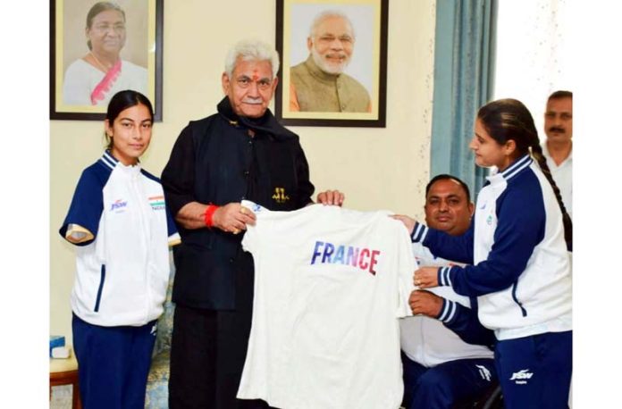 Jersey being presented to Lieutenant Governor Manoj Sinha during meeting with Sheetal Devi and Rakesh Kumar.