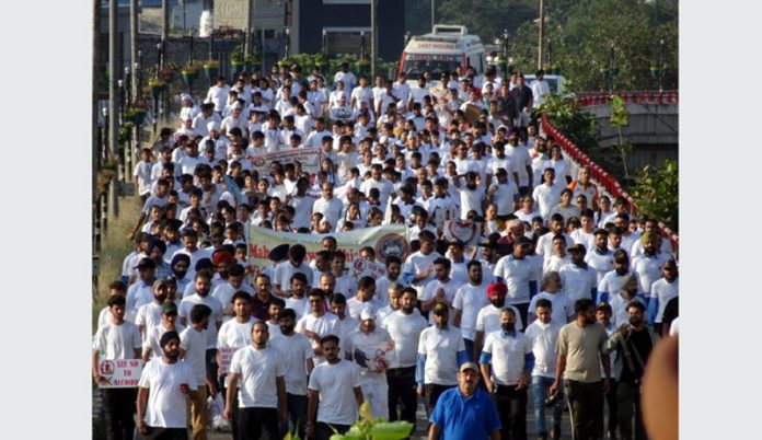 Hundreds of people passing through Bikram Chowk flyover during a walkathon at Jammu on Sunday.