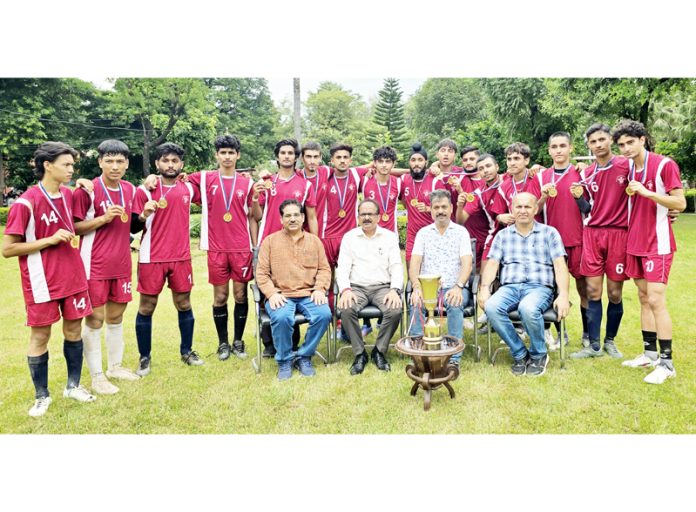 Football team posing with the college staff.