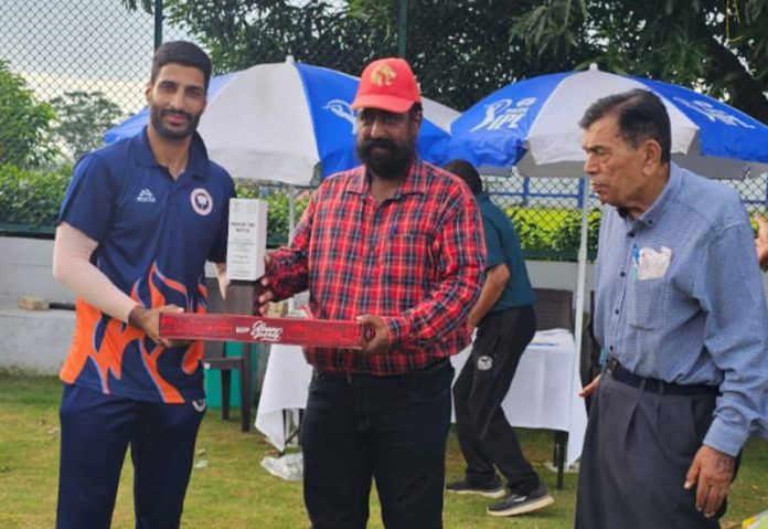 Player of the match receiving trophy from dignitary.