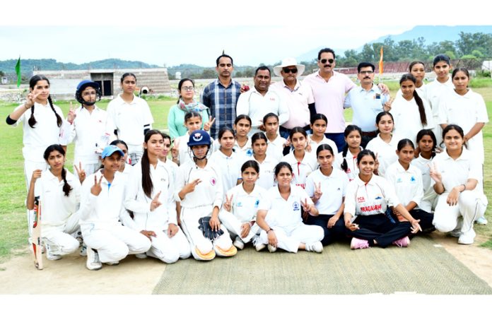 Girls Cricket team posing for group photograph.