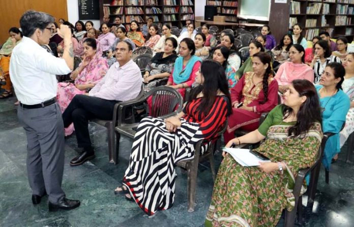 Teaching faculty listening keenly to speaker during a workshop.