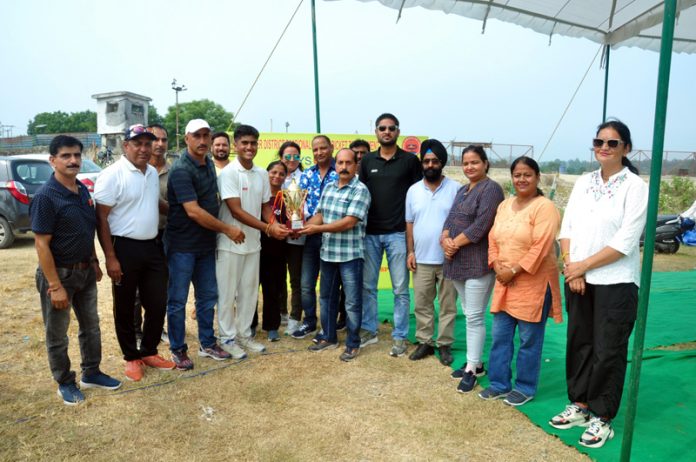 A player receiving trophy from dignitary during closing ceremony of cricket tournament.