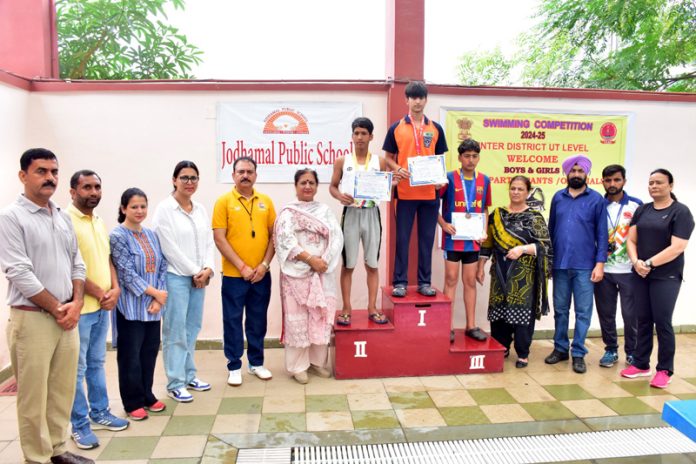 Winners posing with medals on podium at Jammu.