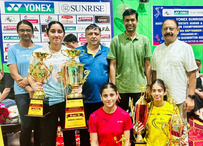 J&K Badminton team and Association members posing along with trophies.