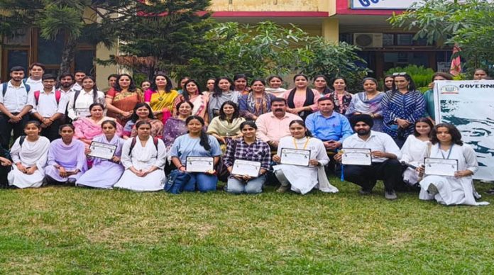 Students displaying certificates while posing with faculty members of GCOE during a programme.