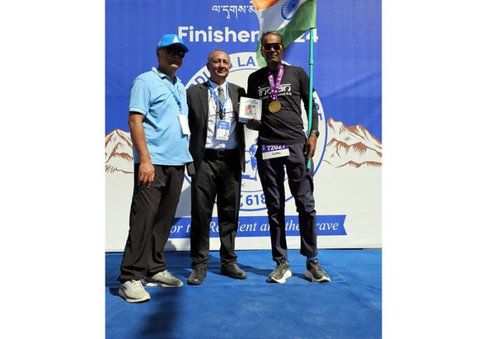 Sudhir Anand posing with dignitary after completing race in Ladakh.