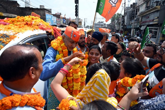 BJP candidate, Sham Lal Sharma being warmly welcomed by his supporters during a road show in Jammu North on Saturday.