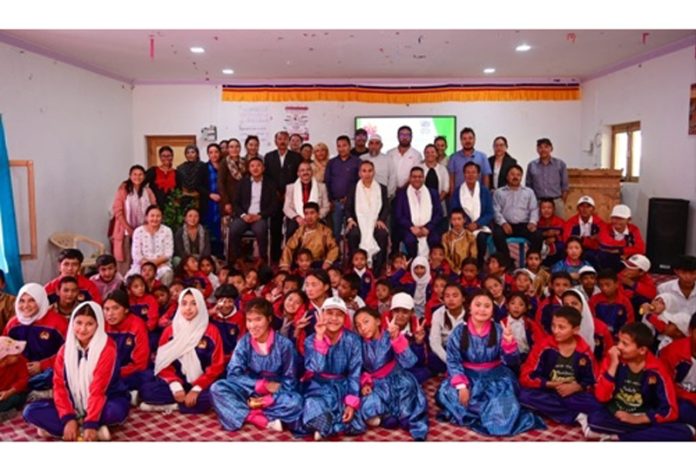 Justice Tashi Rabstan along with others posing with children of the school.