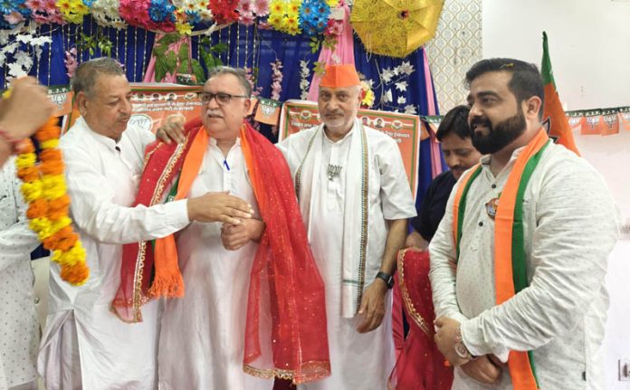 Cong leader Raman Sharma joining BJP in presence of senior BJP leader Sham Lal Sharma in Jammu on Monday.