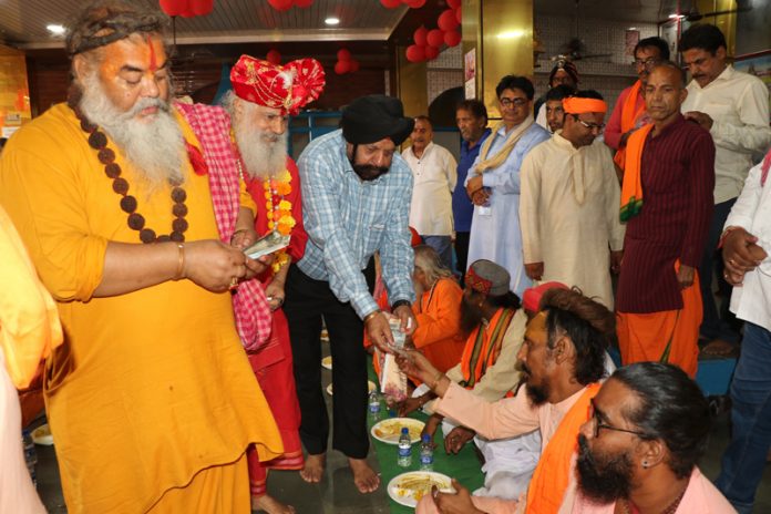 Devotees being served prasad at Baba Sidhgoria Dham at Paloura in Jammu on Sunday.