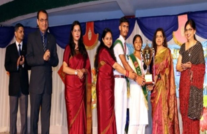 Dignitaries presenting trophy to students during Annual Day event.