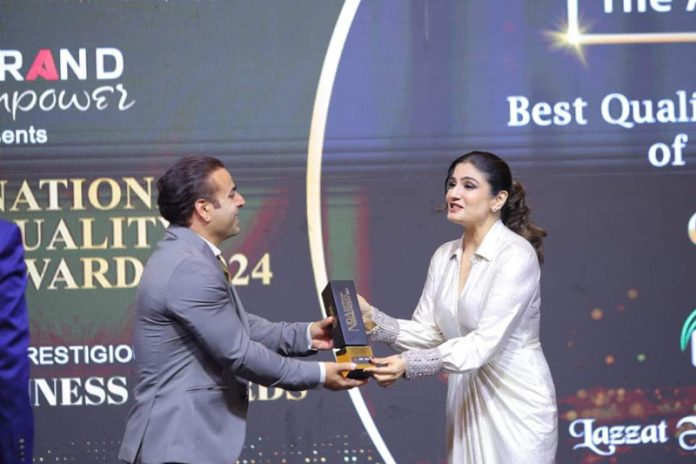 Aijaz Ahmad Bhat, owner of Lazzat Foods and Spices, receiving an award from renowned actress Raveena Tandon during a function in Delhi.