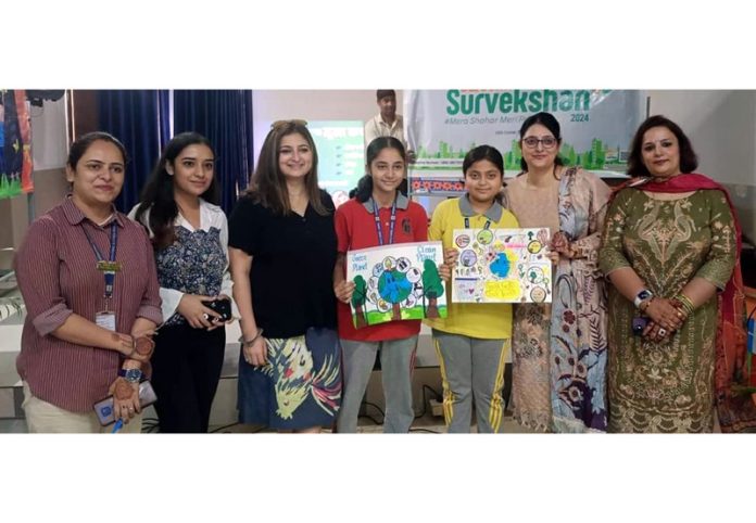 Students along with officials from JMC Jammu showcasing their artworks on Tuesday.