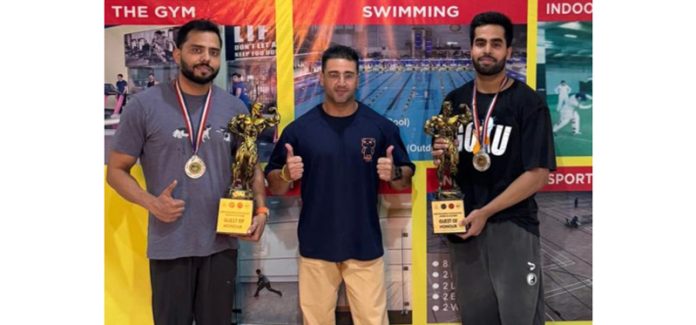 Body Builders Rishab and Arun display their medals with their coach, Vimal Jit in Jammu.