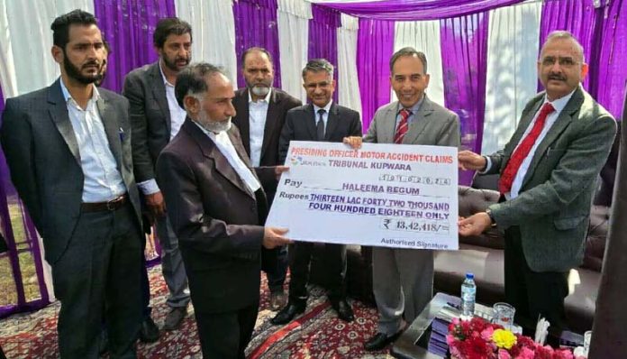 Chief Justice handing over compensation cheque in MACT case at Kupwara.