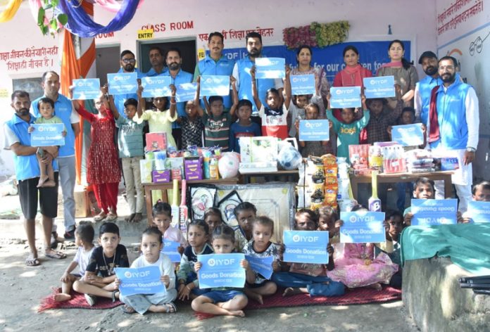 IYDF officials posing with needy youth and children after donating essential relief material.