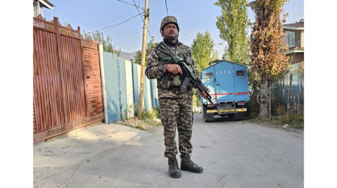 A security personnel stands guard during NIA raid at Sangri Colony in Baramulla on Saturday. —Excelsior/Aabid Nabi