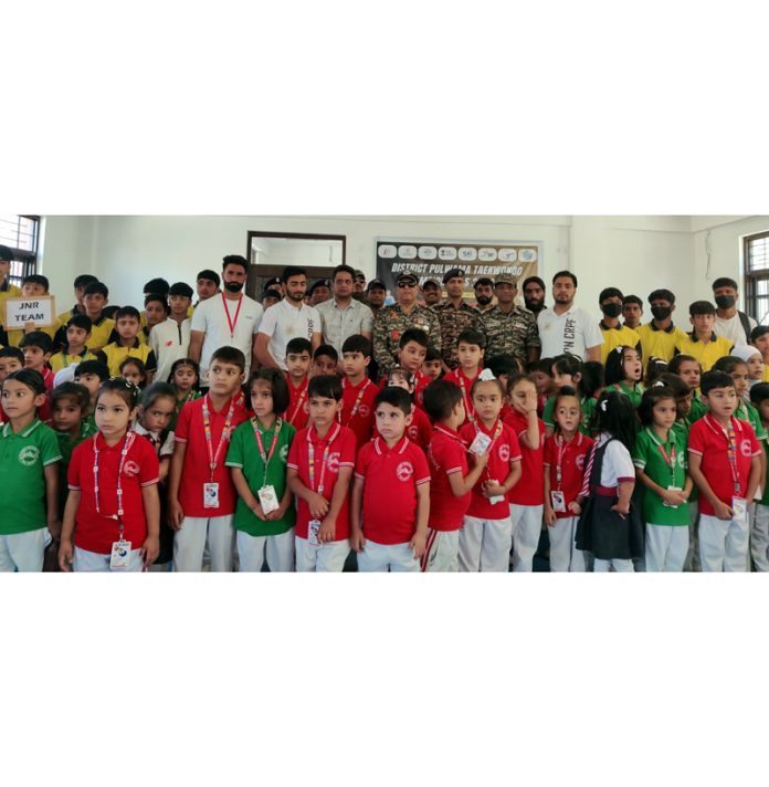 Young Taekwondo players posing along with CRPF officers at Pulwama.