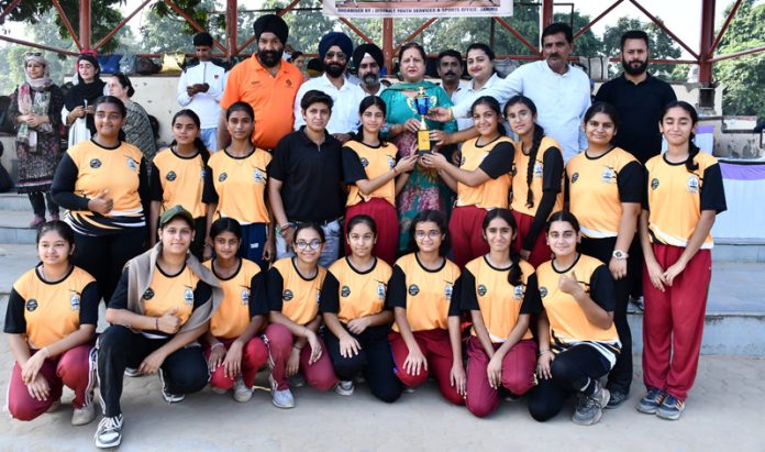 Winning Softball team posing along with trophy.