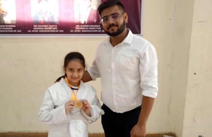 Hetika Gupta displaying Gold medal while posing with a dignitary at Indoor Complex, Bhagwati Nagar in Jammu.