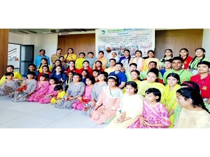 Children posing for a group photograph at Borderless World Foundation (BWF) along with dignitaries.