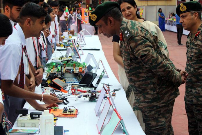 Army officer inspecting students display work during exhibition at APS Akhnoor.