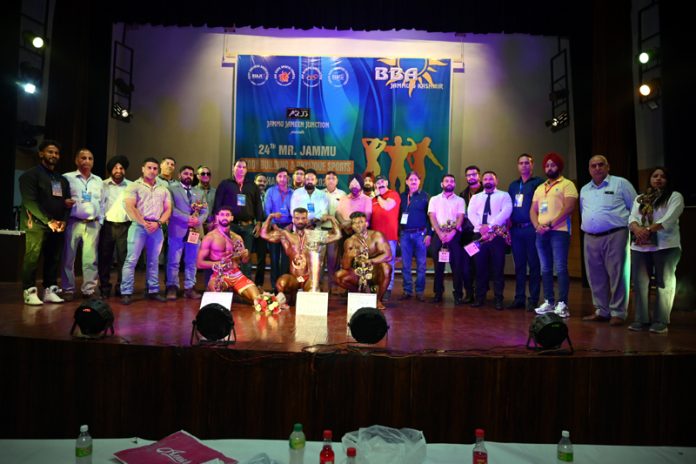 Dignitaries posing along with bodybuilders during an event.