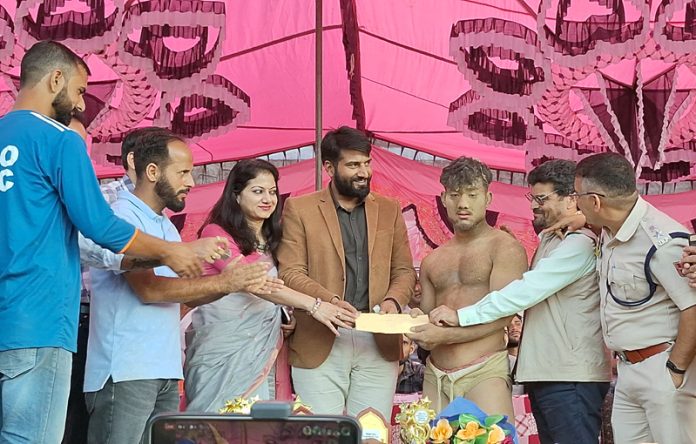 Dignitaries presenting a cheque to winner wrestler at Bhaderwah during Dangal event.