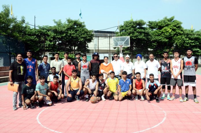 Basketball team posing along with dignitaries during a match.