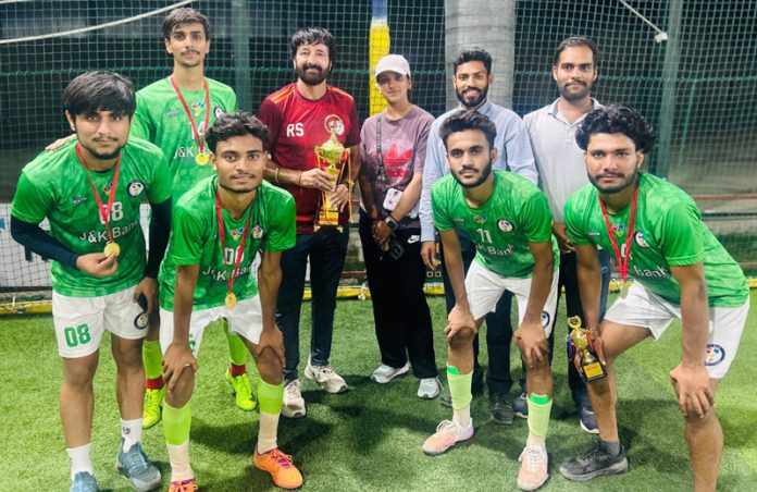 Winning team posing along with trophy.