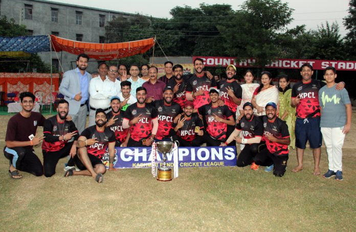 Winning team posing along with trophy.