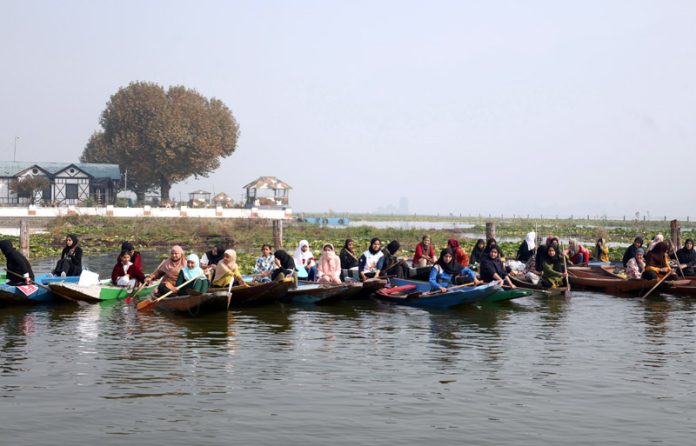 Participants in action during the first-ever traditional women's boat race at Dal lake on Sunday. -Excelsior/Shakeel