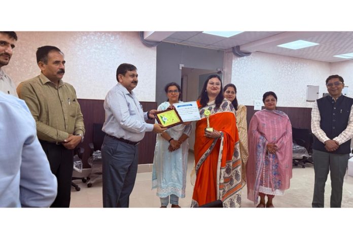 Director School Education Jammu, Ashok Kumar Sharma honouring a teacher during a program on Tuesday.