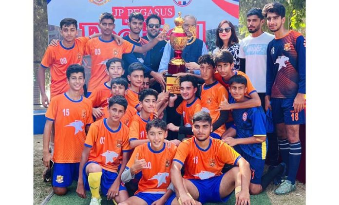 Winning team posing along with dignitaries and trophy.