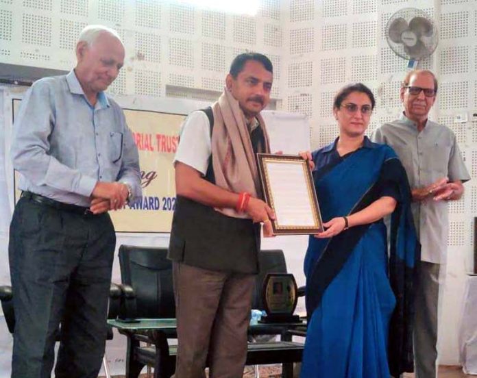 MLA Ranbir Singh Pathania receives award from Neha Jalali, Director PIB during a function at Jammu on Friday.