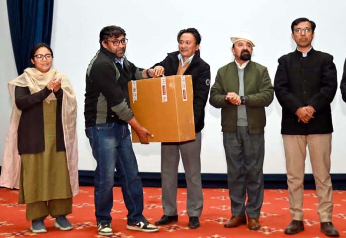 CEC Kargil, Dr Mohd. Jaffer Akhoon distributing the home stay items during a function in Kargil on Tuesday.