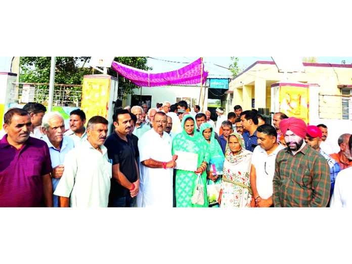 MLA Vijaypur, Chander Parkash Ganga presenting certificates to farmers in Bari Brahmana on Wednesday.