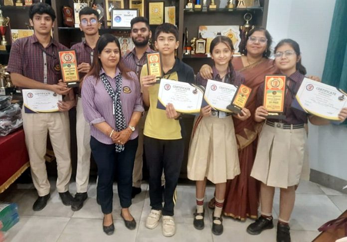 Students of KC International School posing with certificates.