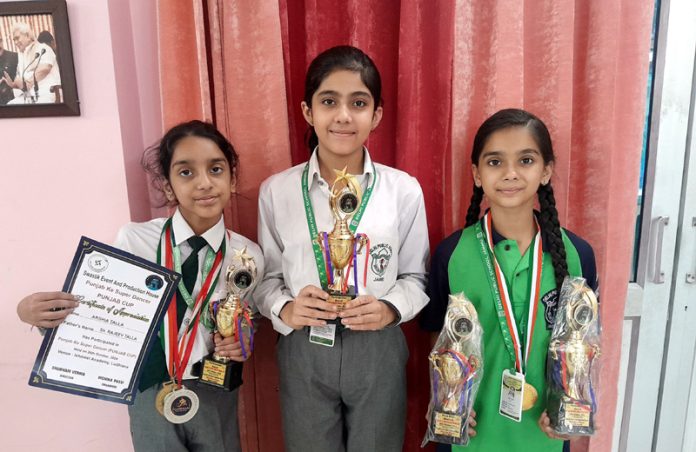 DPS Jammu students display medals and trophies they won at a national level Dance Championship.