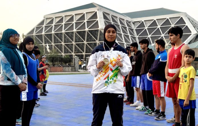 Bareena posing with her gold medal at Indoor Stadium in Srinagar on Monday. -Excelsior/Shakeel