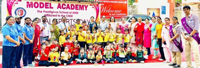 Students posing along with teaching staff, dignitaries during annual sports day event.