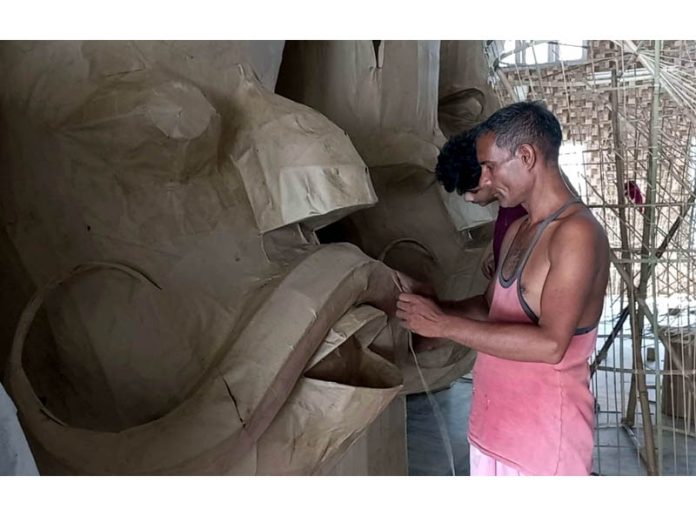 An artist busy in making effigies for upcoming Dussehra festival in Jammu on Wednesday.