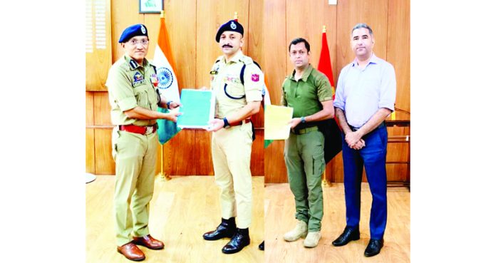 ADGP Jammu Anand Jain presenting police officers Mohan Lal Sharma and Sahil Mahajan with certificates of appreciation on Saturday.