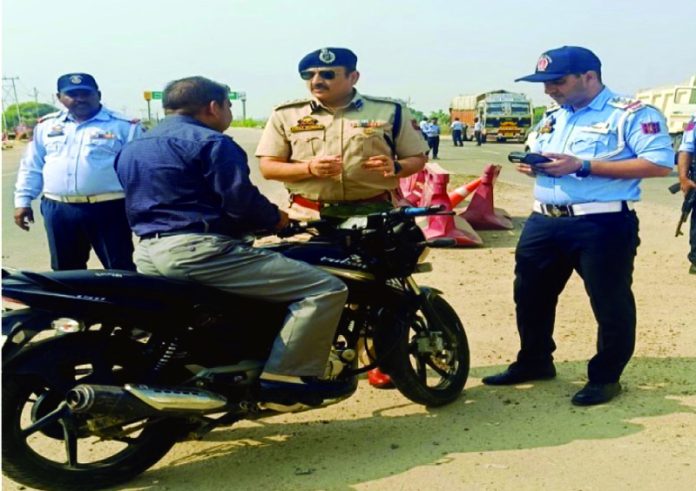 SSP Traffic Rural Jammu Vinay Kumar counselling a biker to wear crash helmet.