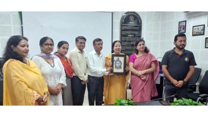 Principal of GCOE presenting Basohli Painting to Romalo Ram during Meet the Alumni Programme.