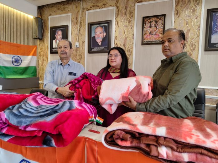 Rattan Lal Gupta presenting blankets and suits to Kavyam Mahajan in Jammu on Thursday.