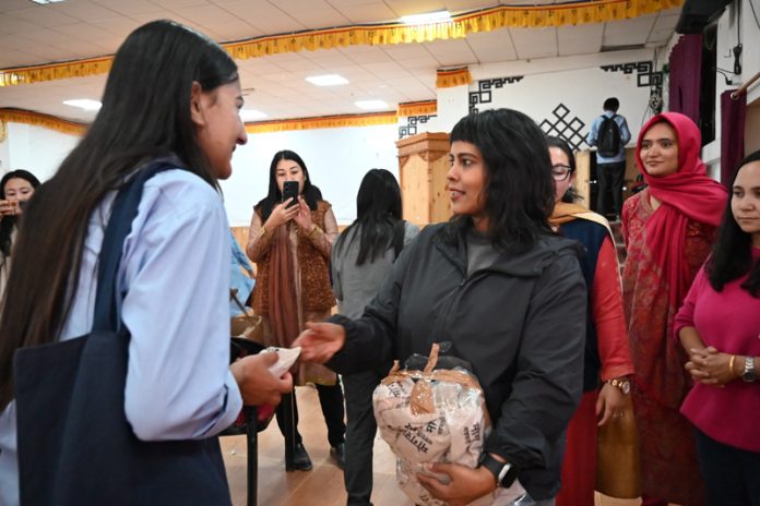 An NGO official distributing menstrual cups to students at EJM College in Leh.