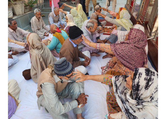 Elder ladies applying Tikka over the foreheads of old-men inmates at an Old Age Home in Jammu on Sunday. -Excelsior/Rakesh