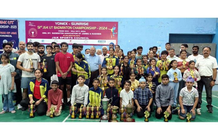 Badminton players posing for group photograph along with dignitaries during prize distribution ceremony.